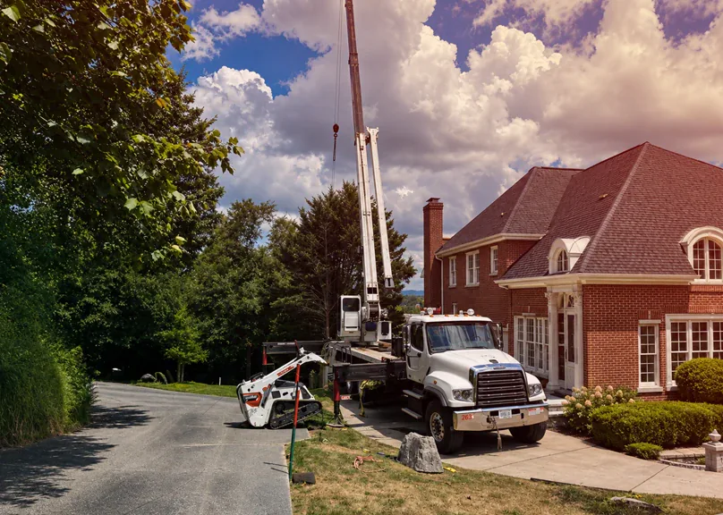 Crane and support equipment positioned for residential tree removal