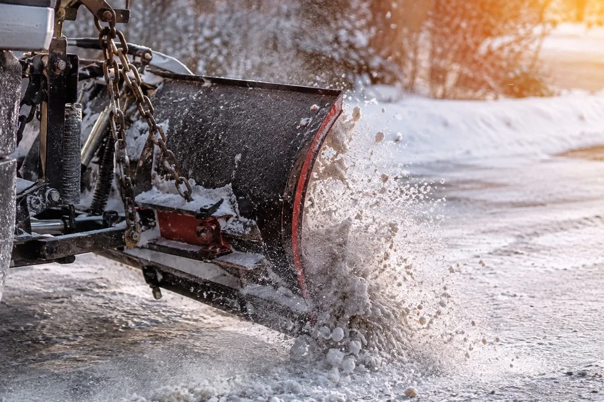 Professional snow plow clearing a paved surface in Fairfield County
